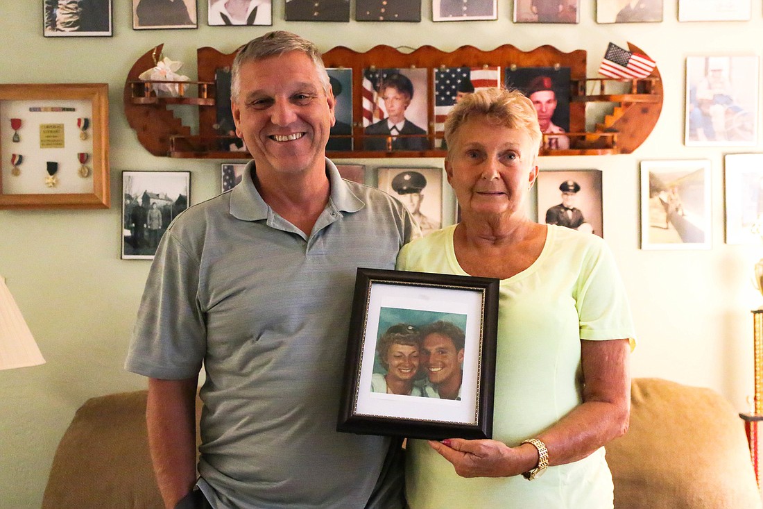Mark and Joyce Grubenhoff, U.S. Army veterans, hold up the first photo they ever took together after meeting in the military. Photo by Paige Wilson
