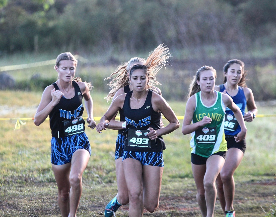 Matanzas runners Kelly Steffens (left) and Rain Marti make a turn during the regional meet. Photo by Ray Boone