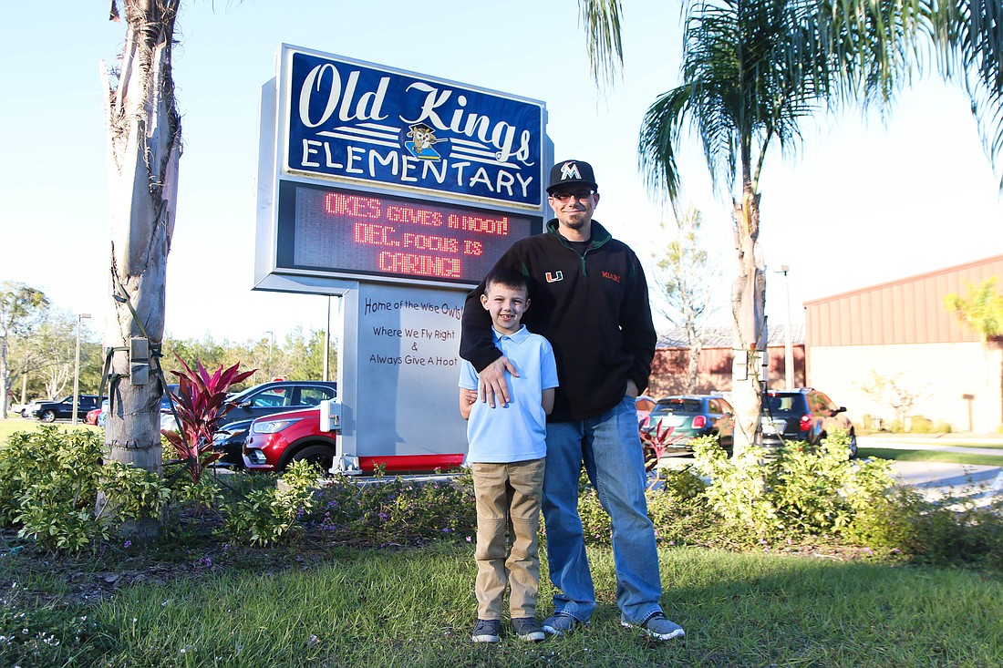 Chris Bruce and his son, Keegan Bruce, stand in front of Old Kings Elementary, where Chris recently started an All Pro Dads chapter to help local fathers engage with their kids' school lives. Photo by Paige Wilson