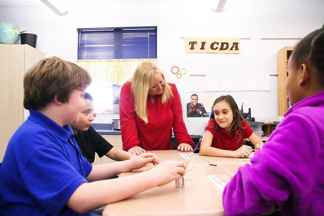 Stacey Smith interacts with her students, Anthony Lamoureaux, Shane Blackwell, Mykayla Brown-Taylor and Alena Ahelezoglo, as they work on a hands-on project. Photo by Paige Wilson