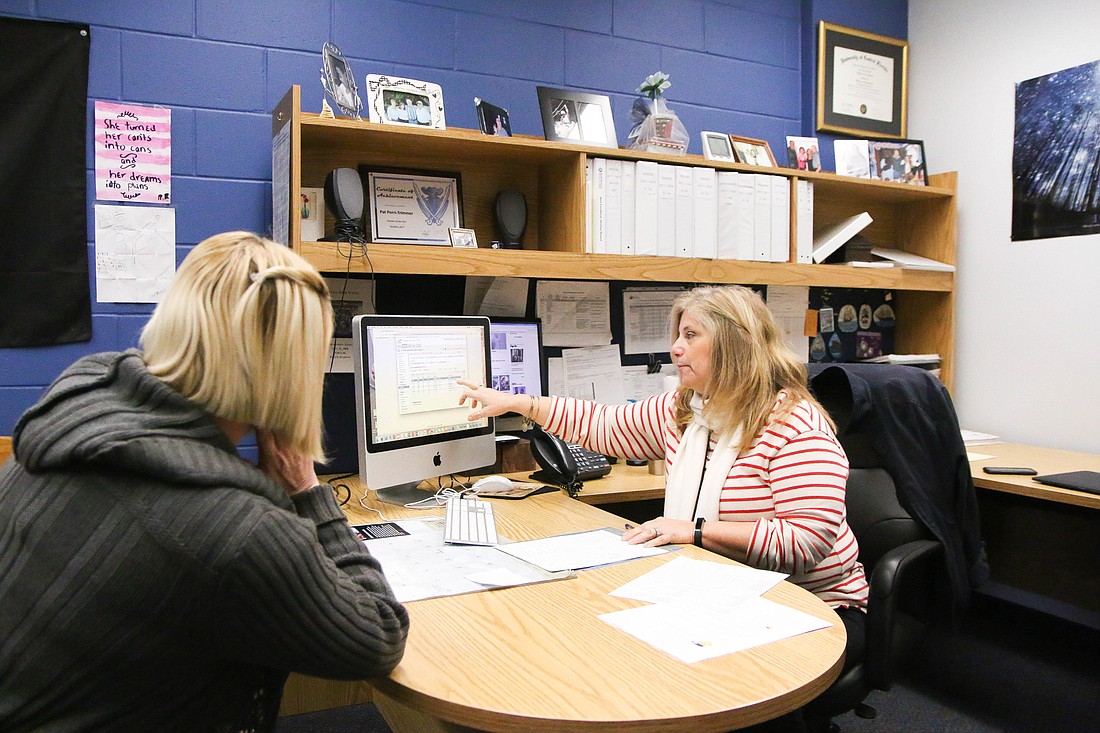 Patricia Perri-Trimmer talks with a parent about a student's grades. Photo by Paige Wilson