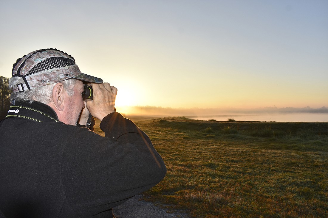 Jim Triplett, a birder from West Virginia, aims his binoculars while birding at the Palm Coast Spray Fields during the 2017 Birds of a Feather Fest. Photo courtesy Cindi Lane