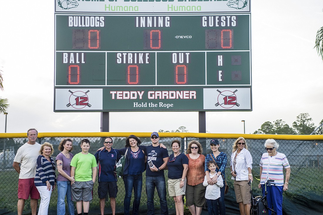 Family and friends celebrate the dedication of the scoreboard, in honor of Teddy Gardner.