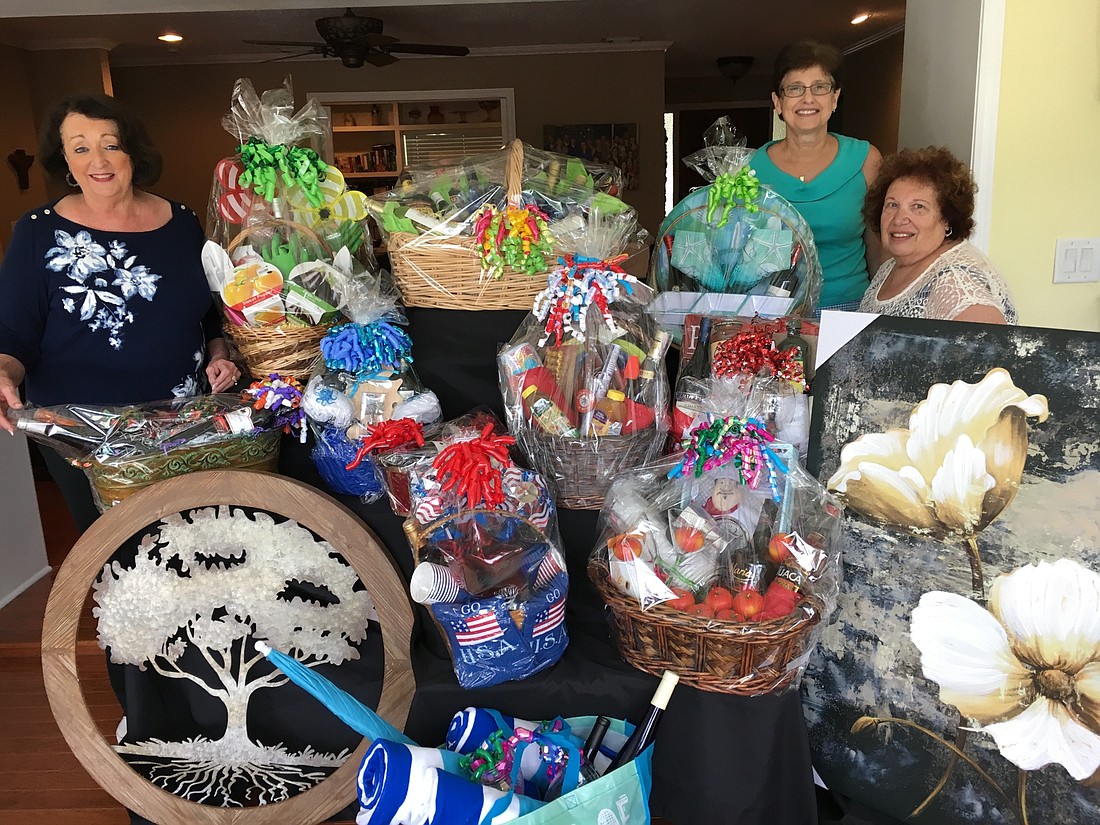 Italian American Club's committee chairperson Mickey Logemann and two committee members Edith Campins and Mary Ann Landolina look over some of the prizes they assembled for the club's annual Las Vegas Night. Not shown is Maureen DeGiulio and Rose Vullo.