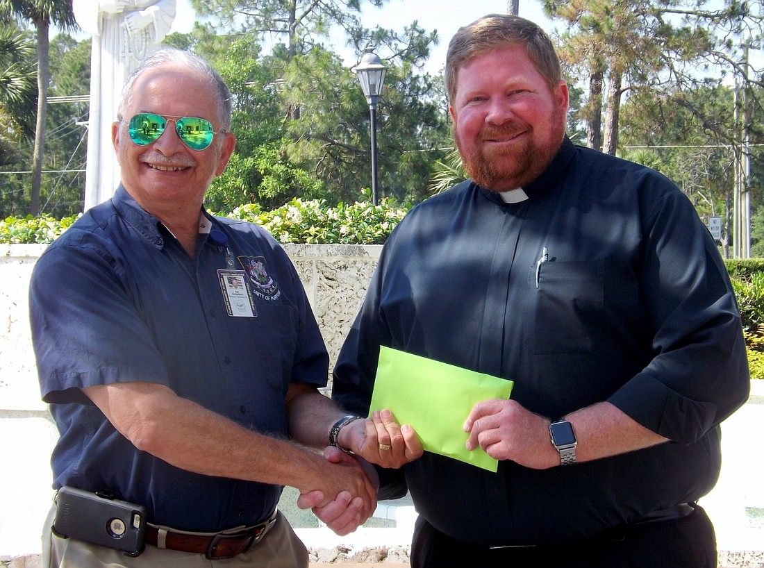 Veteran Services officer, Sal Rutigliano receives 28 food gift card for local veterans from Father Jason Trull of St. Elizabeth Ann Seton Catholic Church.