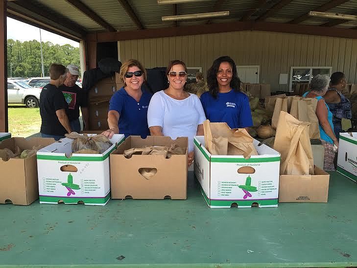 Florida Hospital Flagler employees Lisa Collier, Rosanne Martin and Naquisha Nelson-Gibson, volunteered with Access Flagler First and helped box groceries for local families in need. Courtesy photo