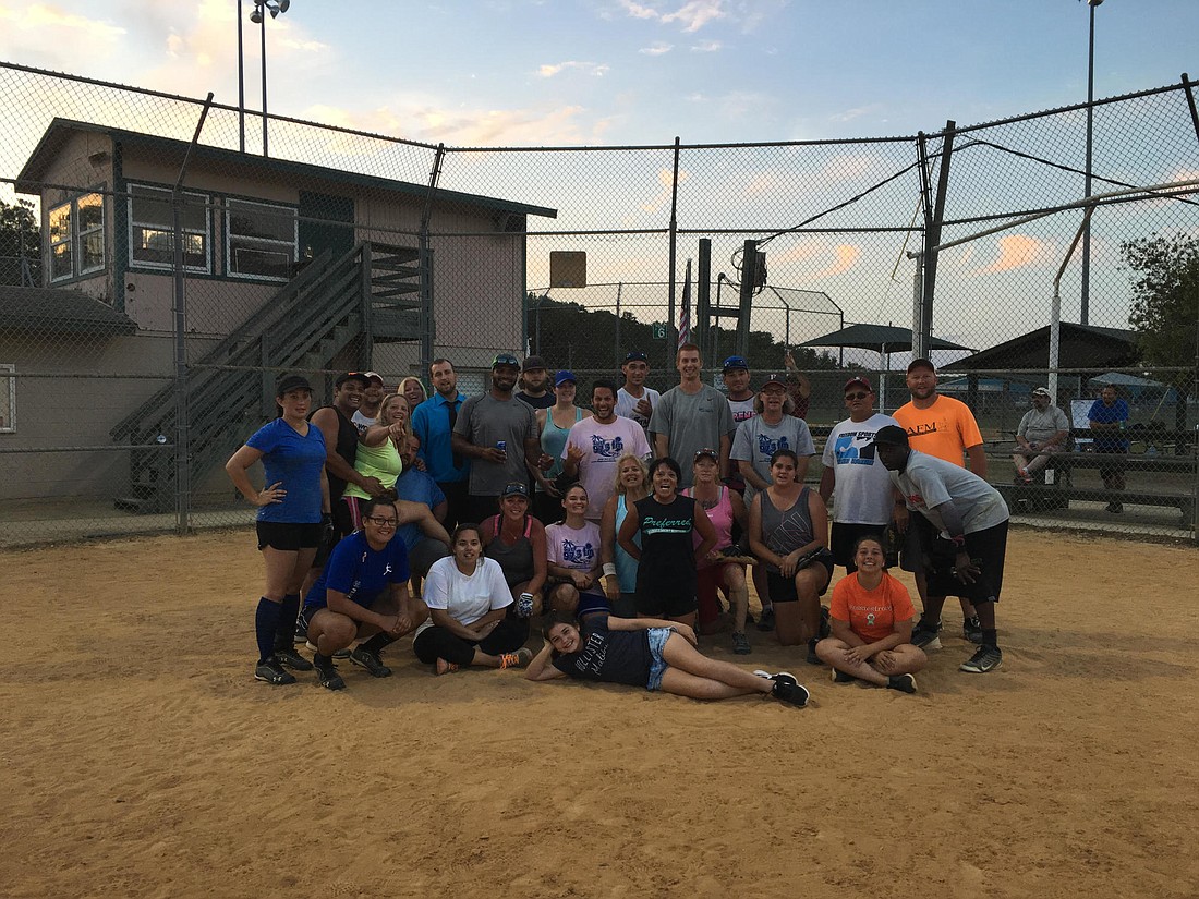 Essie lays down in front of winning team Atlas at a softball tournament that raised money for her medical expenses.