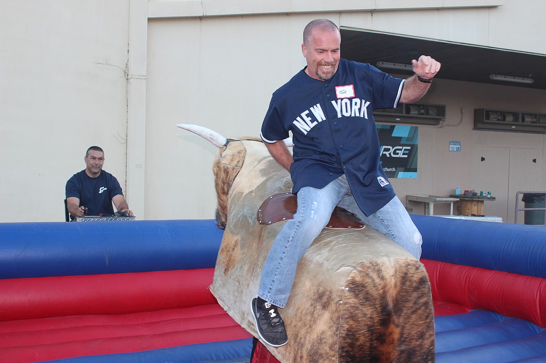 Joe Costello stayed on the mechanical bull longer than the other guys who rode it frontwards. Photos by Jeff Dawsey