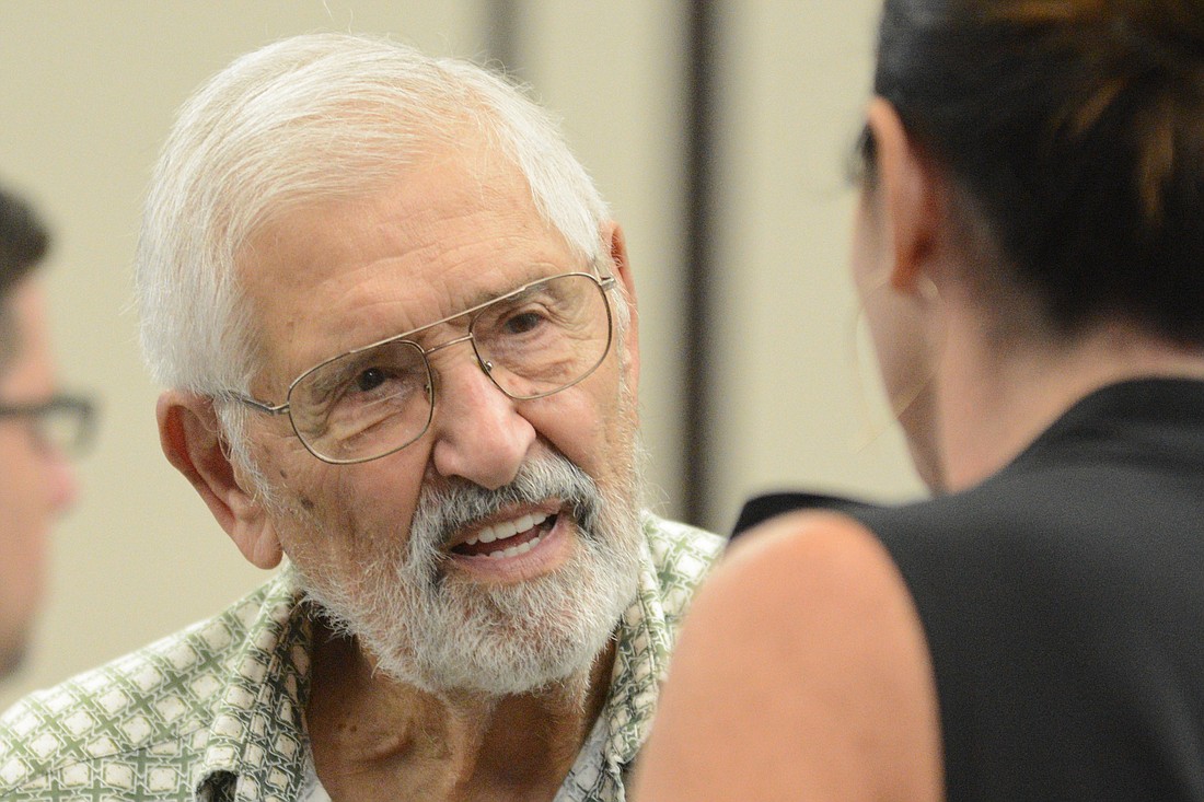 Palm Coast resident Jack Carall, who questioned spending more taxpayer money on the Palm Harbor Golf Club, speaks to Palm Coast mayor candidate Milissa Holland after an Aug. 16 City Council meeting. (Photo by Jonathan Simmons)