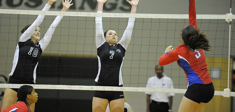 Morgan Keefer and Marian Robertson attempt to block a shot by a Tampa King outside hitter.
