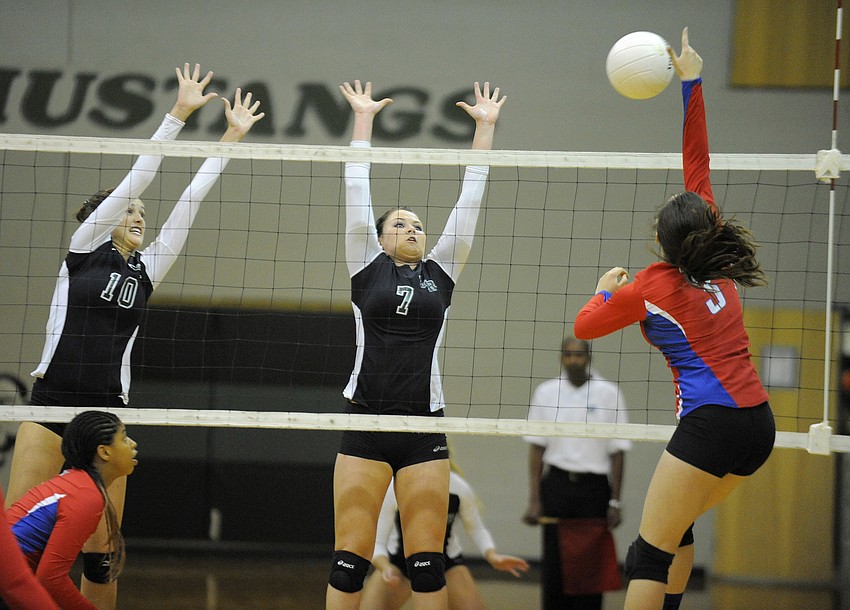 Morgan Keefer and Marian Robertson attempt to block a shot by a Tampa King outside hitter.