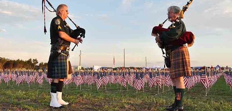 Bagpipers led a procession of emergency vehicles.