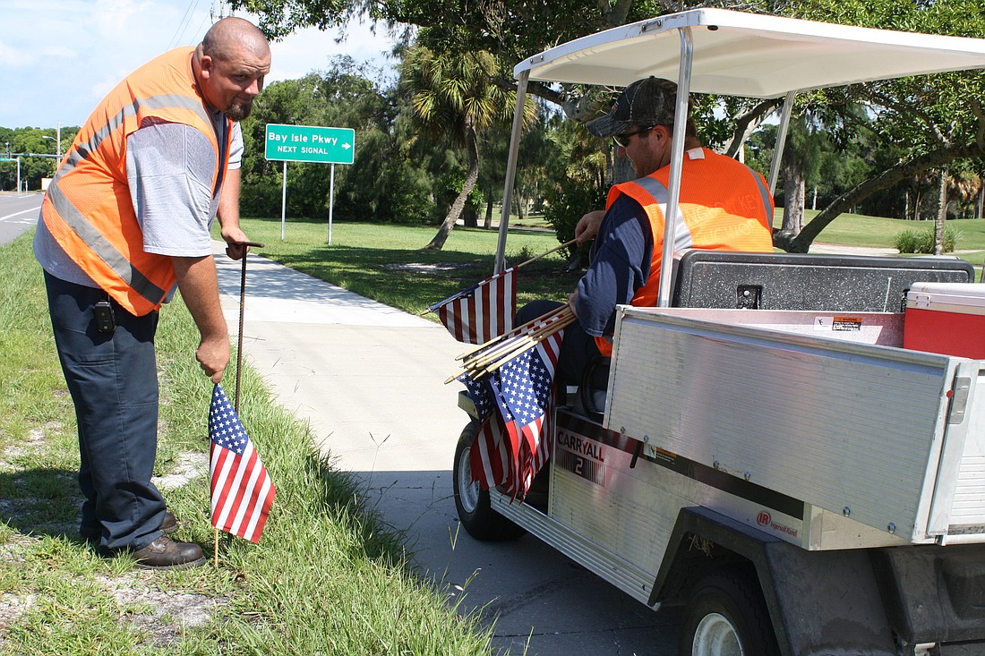 Doyle Walker and Curtis Vandernolen, with Longboat Key Public Works, line Gulf of Mexico Drive with American flags Saturday, Sept. 10.