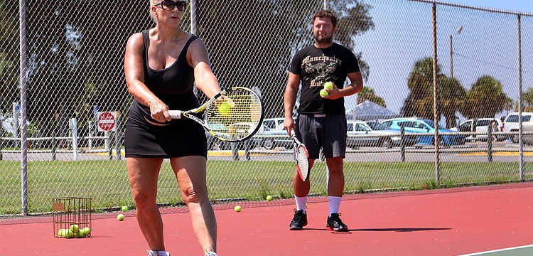 Michelle Zirkle works on her serve during her tennis lesson with tennis pro Michael Skwira out at the Siesta Key Public Beach Courts.