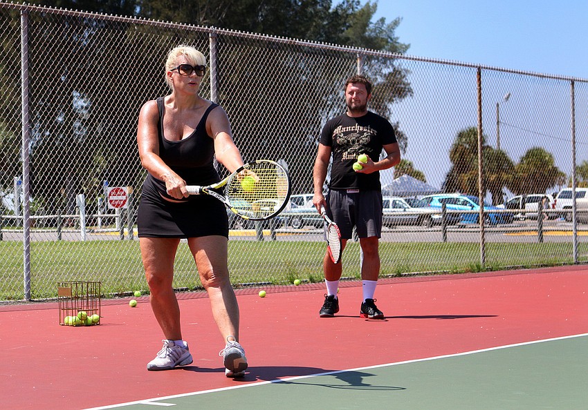 Michelle Zirkle works on her serve during her tennis lesson with tennis pro Michael Skwira out at the Siesta Key Public Beach Courts.