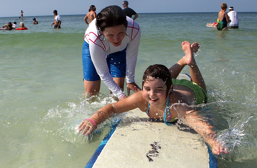 Michelle Stauffer helps Molly Pyrott, 7, during the Hang Ten for Autism surf event Saturday, Sept. 17, at the Siesta Key Public Beach.
