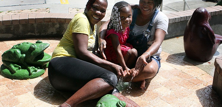 Gladys Jackson, Tarnara Byoce, 3, and Shwntel Thomas enjoy splashing around in the smaller fountain area of the Steigerwaldt/Jockey Children's Fountain at Bayfront Park.