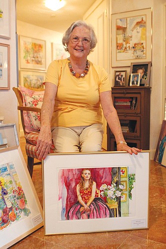 Marcia Freedman displays one of her more recent watercolor paintings. She prefers painting watercolors to oil paintings.