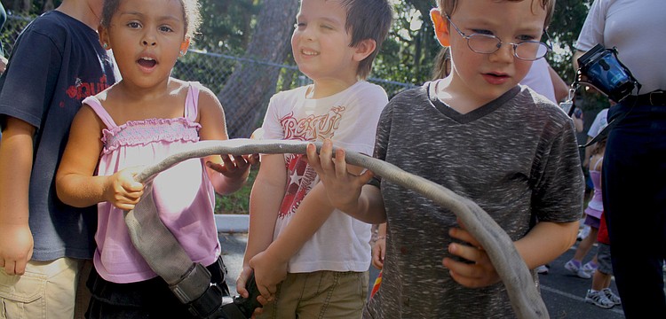Francesca Magnotti, Liam Lizotte and Chance McArtor play with the fire hose.
