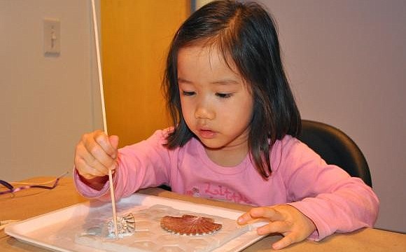 SARASOTA: Hannah Smith, 3, puts decorative, little holes into her clay slab.