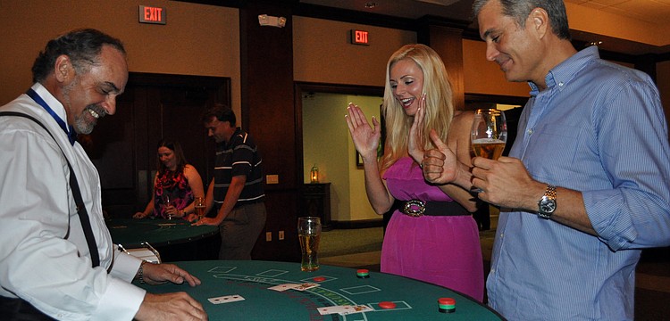 Melissa Fox and Peter Simonson celebrate after beating dealer Rick Vargas at blackjack.