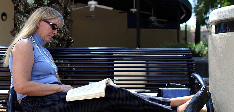 Dawn Davis enjoys catching up on her reading and having a macaroni salad for lunch during her lunch break from her work at Superior Bank.