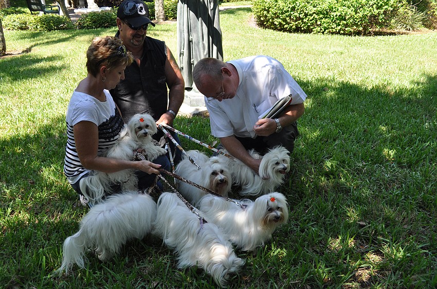 Rev. Bernthal blesses Marianne and Dan Blazowich's six dogs.