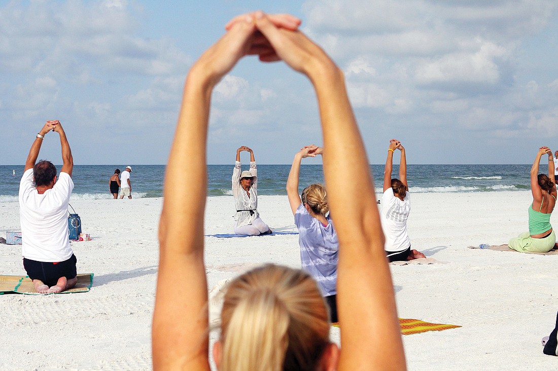 Ava CsiszarÃ¢â‚¬â„¢s free beach yoga classes have been drawing steady participation on Siesta Key Public Beach. File photo.