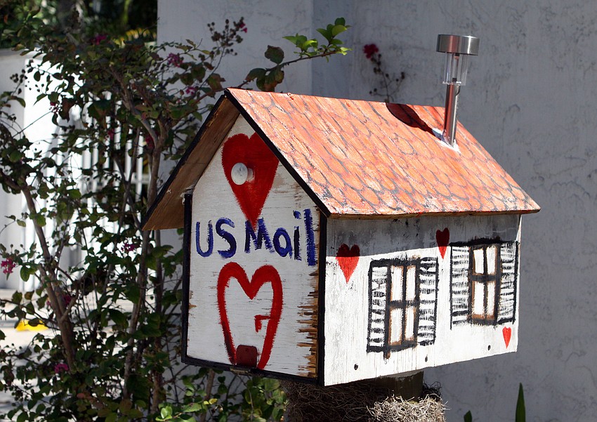 A mailbox on Higel Avenue is designed to look like a house and has been painted with hearts, windows and 