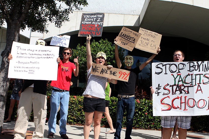 Occupiers cheer and wave their homemade signs as a car passes by with honks of encouragement Thursday, Oct. 6 during the Occupy Sarasota demonstration outside of Bank of America on Main and Orange downtown.