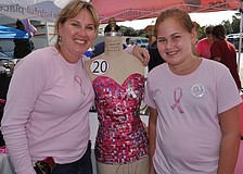 Summerfield resident Michelle Clinton, with her daughter, Ava, stands next to the bra she made out of recycled Tab and strawberry Sunkist.