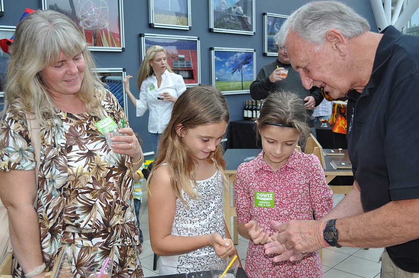 Joe Clifford with the Magic Club performs a trick for Brigitta Kellihar, Shari Soavi, Alexandra Belz.