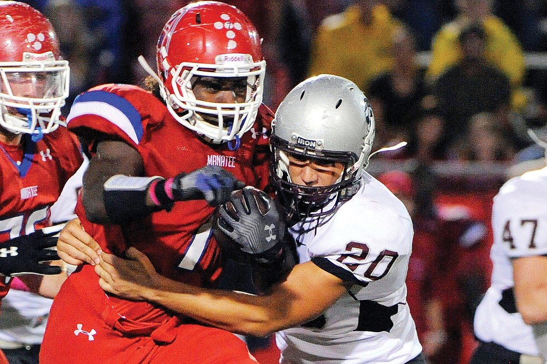 Sophomore linebacker Marcus Balliette tries to wrap up Manatee wide receiver Ryan Taylor.