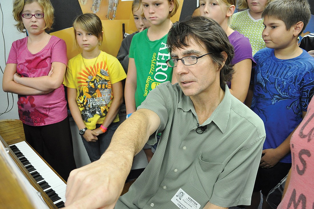 Composer Gregory Smith plays a song he is writing for students at Gene Witt Elementary. The piece features melodies written by select students at the school