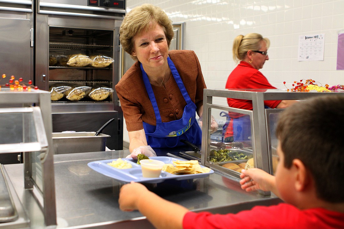 Superintendent Lori White hands over a lunch tray Thursday, Oct. 13, at Gulf Gate Elementary.