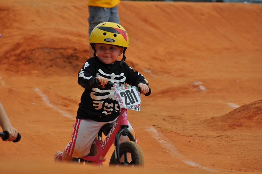 A toddler tests out a possible Halloween costume as she races around the track.