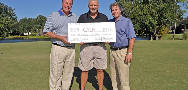 Earl Persinger and Todd Byers of the Golf Prize Stop presented River Club golf course owner Mike Pascuzzi, center, with a $1,000 check Oct. 25 for hitting a hole-in-one during a charity golf event last month.