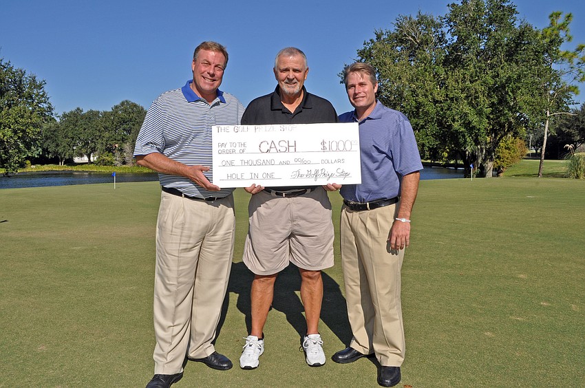 Earl Persinger and Todd Byers of the Golf Prize Stop presented River Club golf course owner Mike Pascuzzi, center, with a $1,000 check Oct. 25 for hitting a hole-in-one during a charity golf event last month.