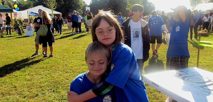 East County resident Joey Baar receives a hug from Ella Quaid during the Manasota BUDS 10th annual Buddy Walk Oct. 22, 2011.