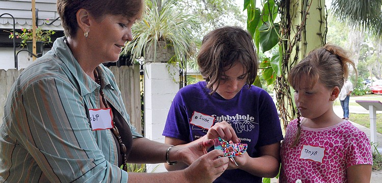 Debi Kleer helps her daughter, Sune Venter, 10, with bedazzling her mask, while her other daughter, Tanya, 8, looks on, Saturday, Oct. 29, during Family Mask Day at Artists on the Court.