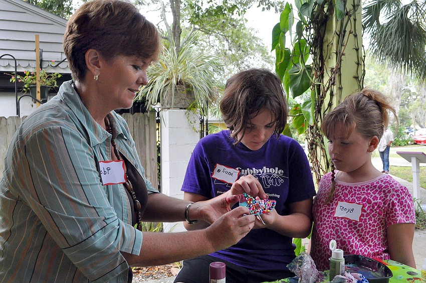 Debi Kleer helps her daughter, Sune Venter, 10, with bedazzling her mask, while her other daughter, Tanya, 8, looks on, Saturday, Oct. 29, during Family Mask Day at Artists on the Court.