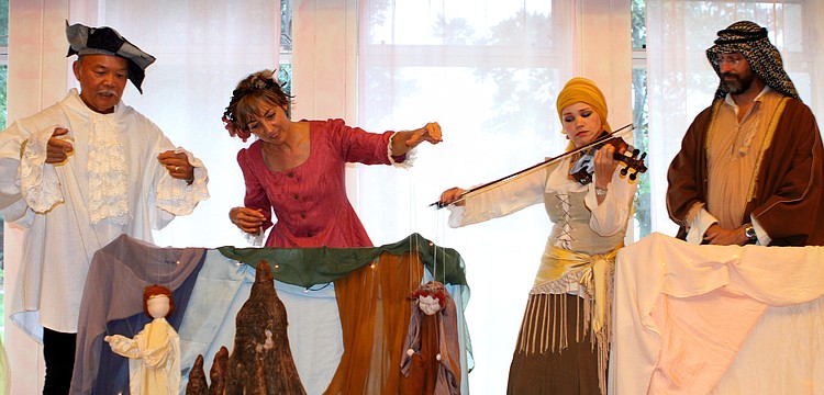 Peter Chin and Connie Manson move the Prince and Witch puppets while Natalia Vasilieva plays the violin and Nicoll Bacharach watches.