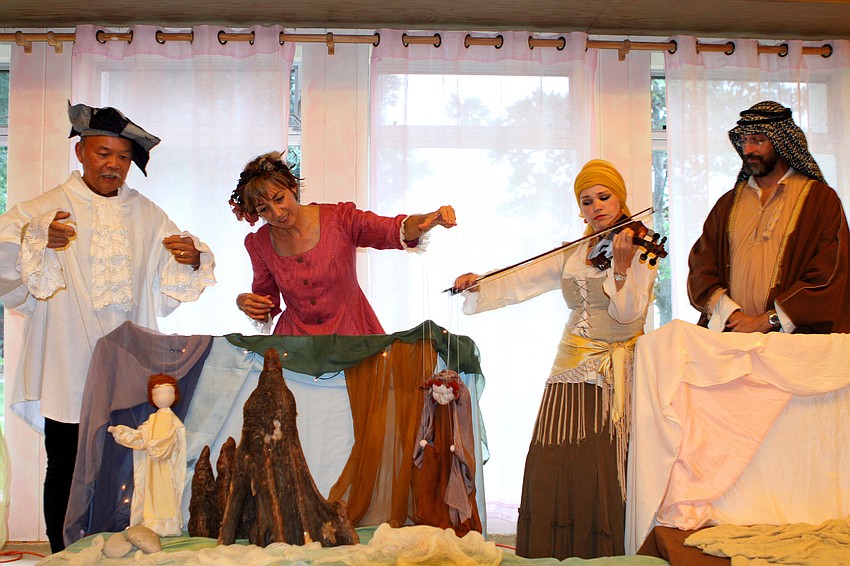 Peter Chin and Connie Manson move the Prince and Witch puppets while Natalia Vasilieva plays the violin and Nicoll Bacharach watches.
