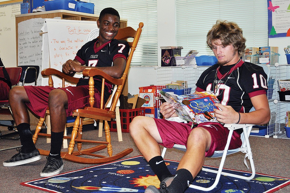 Freshman Justin Ross and senior Ryan Fischer read the "The Quiltmaker's Gift" to a group of fifth-grade students.