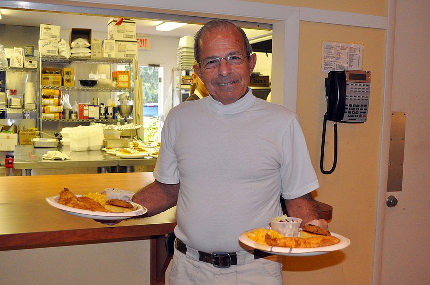 Gary Porretta picks up two plates, one for himself and one for his wife, Mary, Friday, Nov. 4, during the fish fry at St. Boniface.