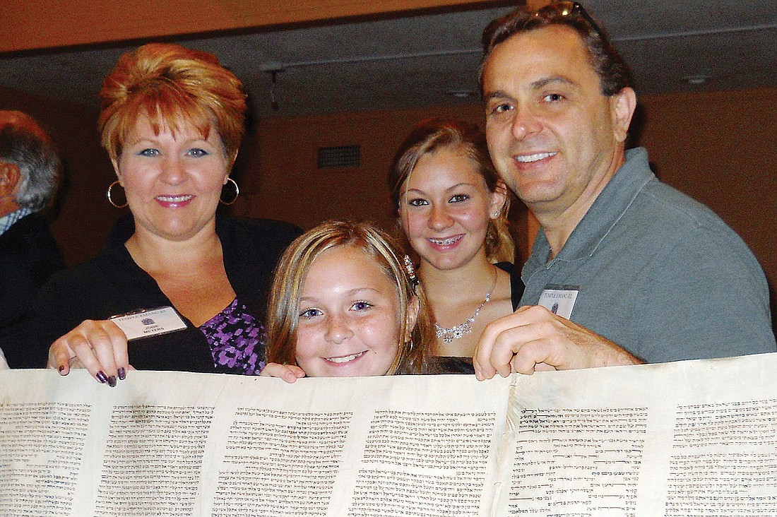 Lakewood Ranch residents Jodie, Sarah, Julia and Don Meyers help hold a 100-year-old Torah scroll.