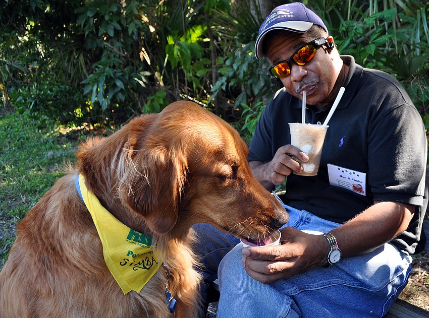 Simba, 4, and Ron Comrie enjoy some ice cream together, Saturday, Nov. 12, at Golden Fest out at Historic Spanish Point Park. Simba had peanut butter doggie ice cream for his treat.