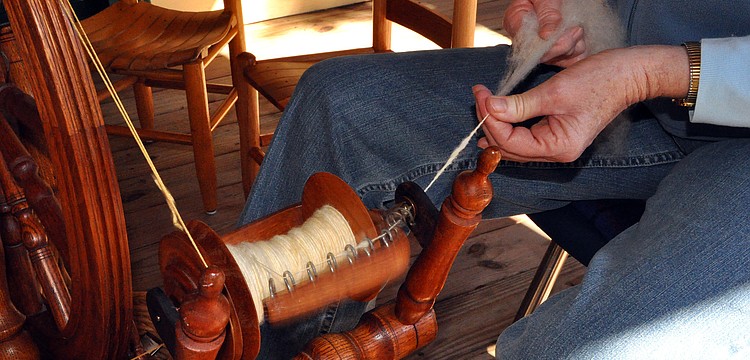 Anne Savage spun wool out on the back porch of the Bidwell-Wood house as part of Pioneer Day.