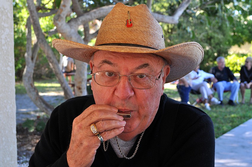 Cowboy Bill Ferguson gave a mini harmonica concert while sitting at his picnic table Saturday, Nov. 12, during Benny Kinsey's Bluegrass Picnic out at Turtle Beach.