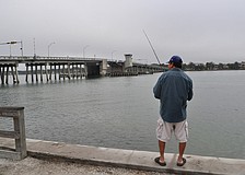Despite the foggy weather and a bit of mist, Tin Truong fishes out at Bay Island Park.
